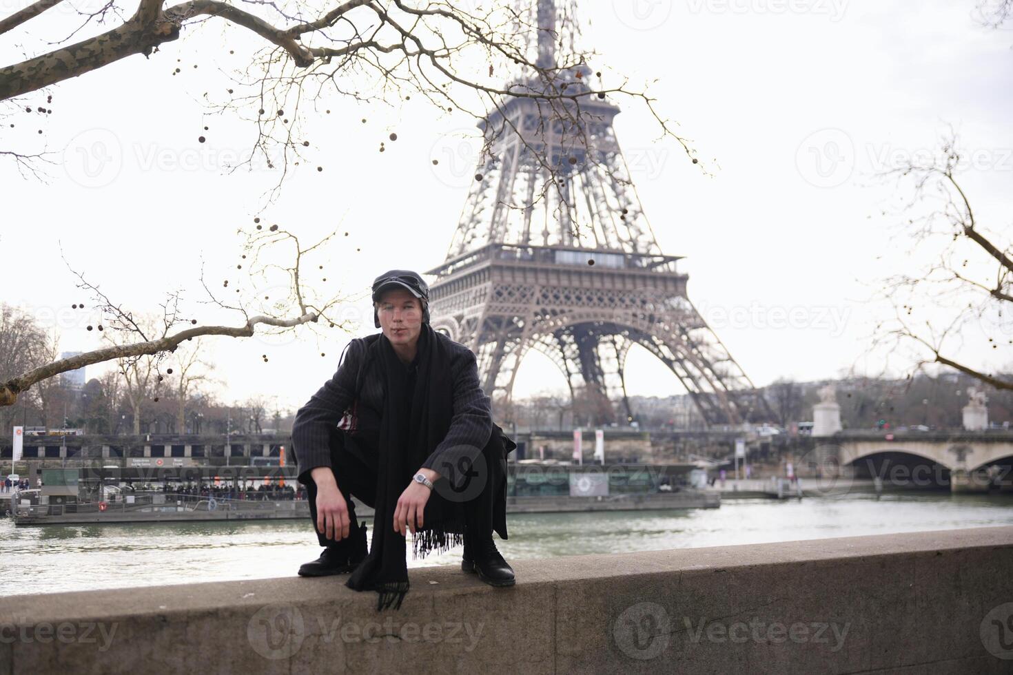 Stylish man squatting near Eiffel Tower in Paris photo