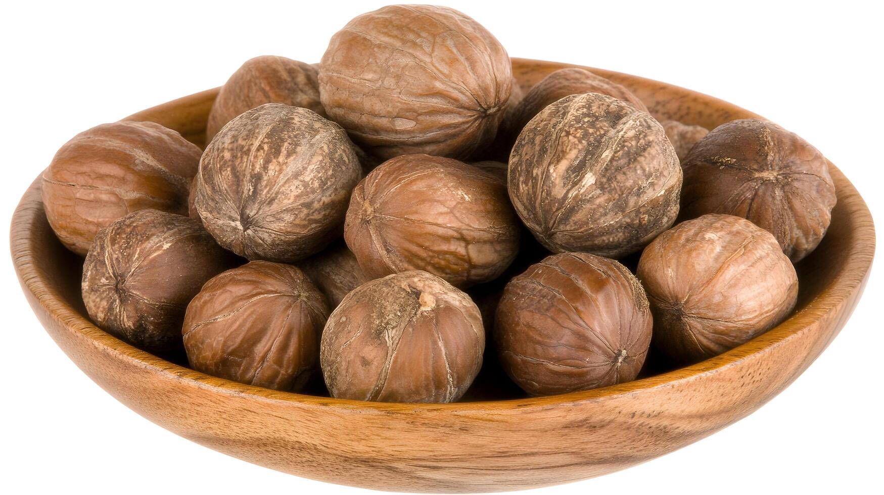 A rustic wooden bowl overflowing with earthy brown nutmeg, a fragrant spice hinting at warm kitchens and comforting autumnal recipes, showcasing its rich, textured surface. photo