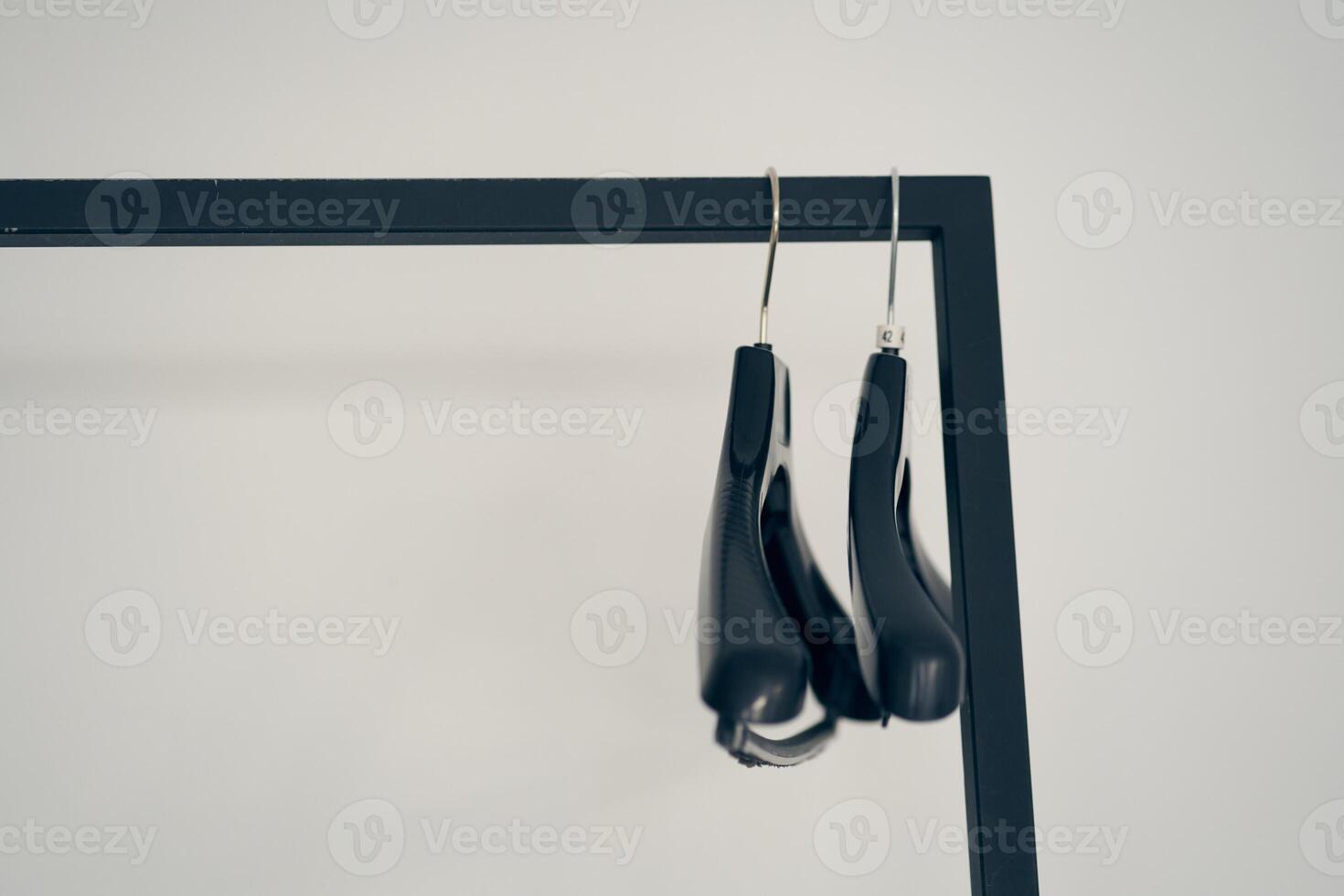 A row of two plastic metal-based clothes hangers. With space to copy photo