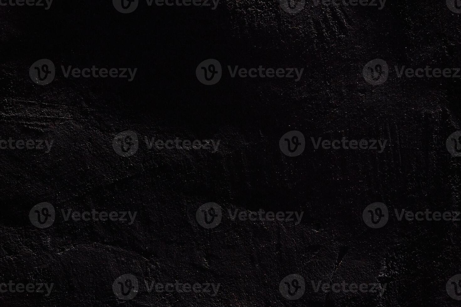 The texture of the black stone surface. Rough uneven wall with scratches with space to copy photo