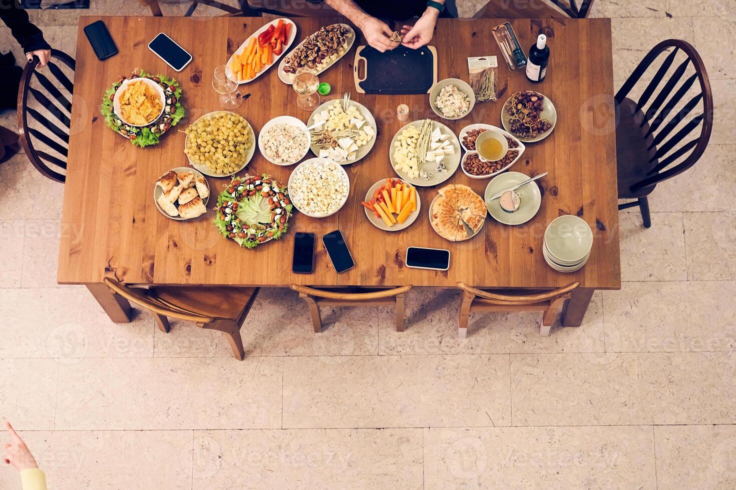 High-angle view of a festive dining table with snacks, vegetables and fruits. A man prepares a table for the holiday. With space to copy photo