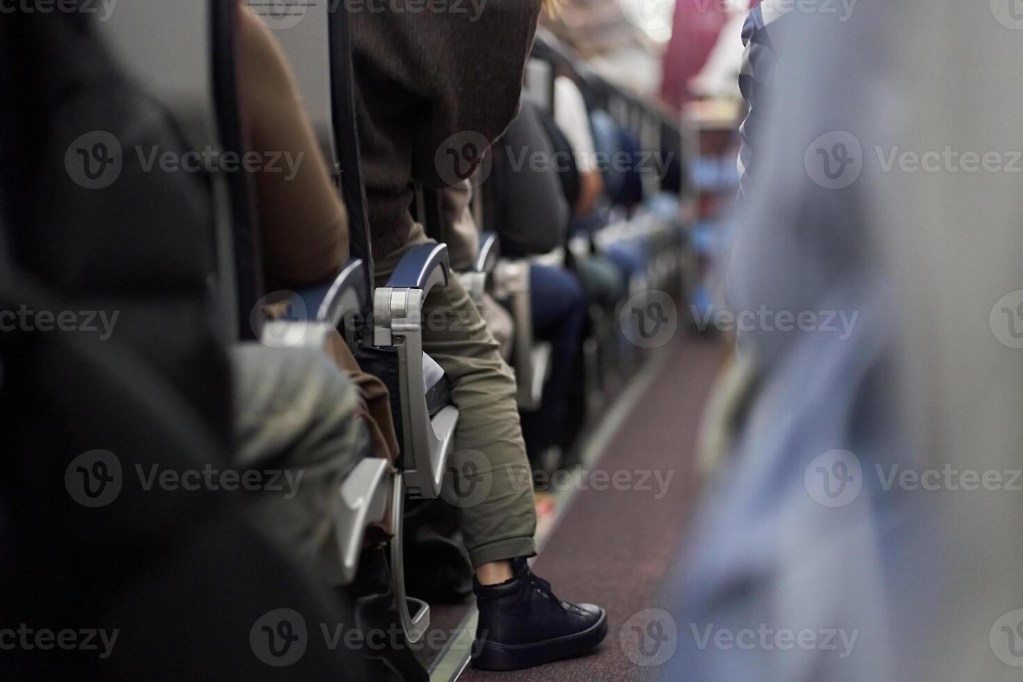 Passengers sit along the row in the plane in their seats. The concept of travel. photo
