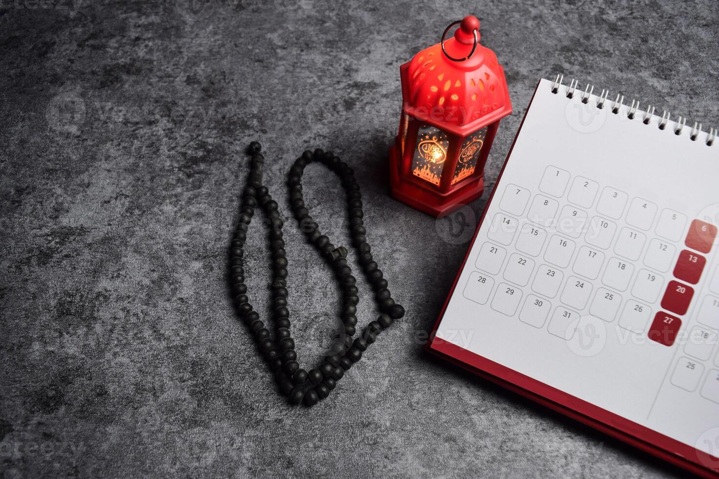 Calendar, prayer beads, golden ramadhan lamp with islamic rosary beads on dark background ramadhan. photo