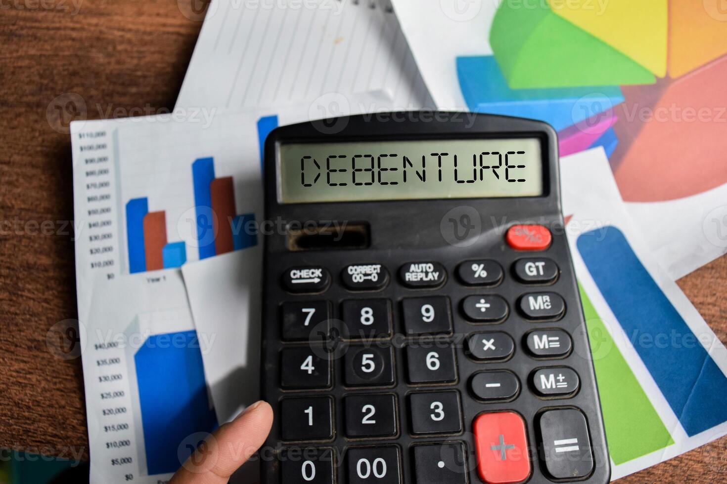 Concept of Debenture write on Calculator isolated on Wooden Table. photo
