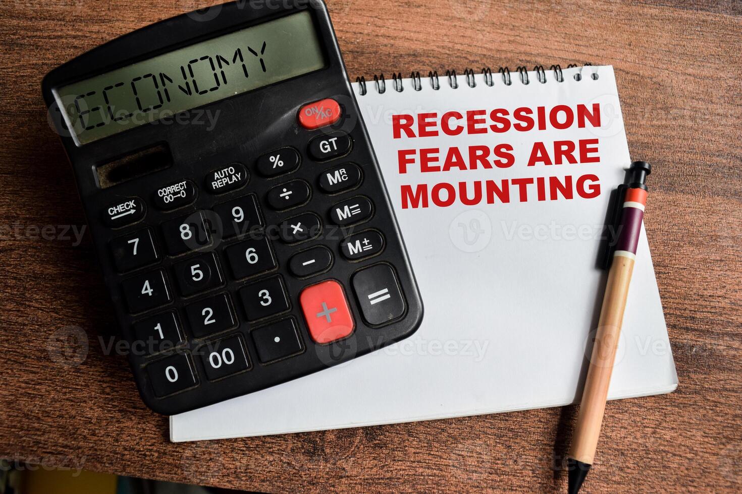 Concept of Recession Fears are Mounting write on sticky notes and Economy text in calculator isolated on Wooden Table. photo
