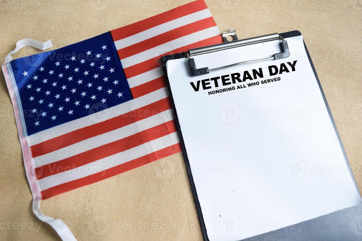 Concept of Veteran Day - Honoring all who served write on paperwork with the united states flag isolated on Wooden Table. photo