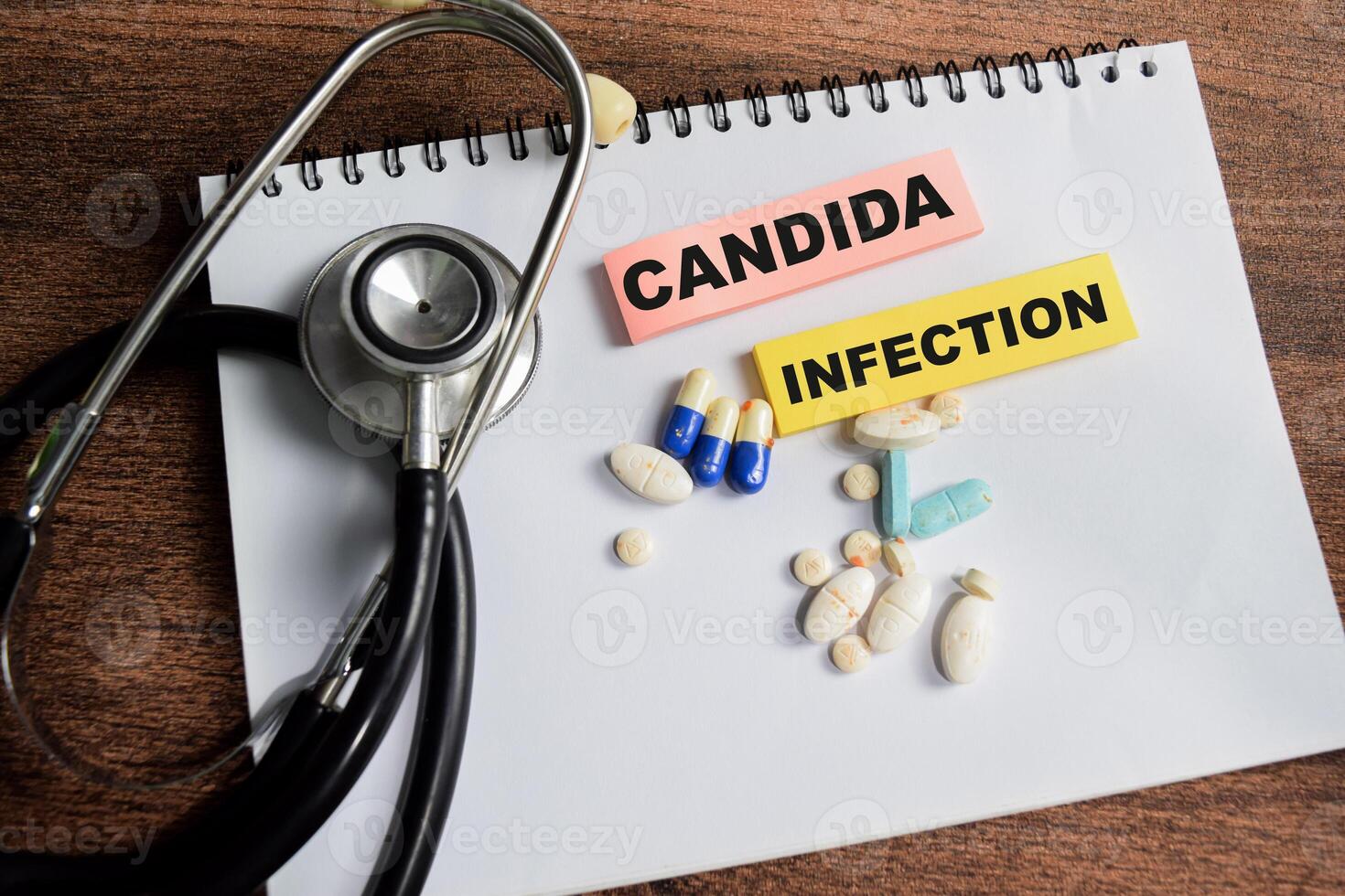Concept of Candida Infection write on sticky notes isolated on Wooden Table. photo