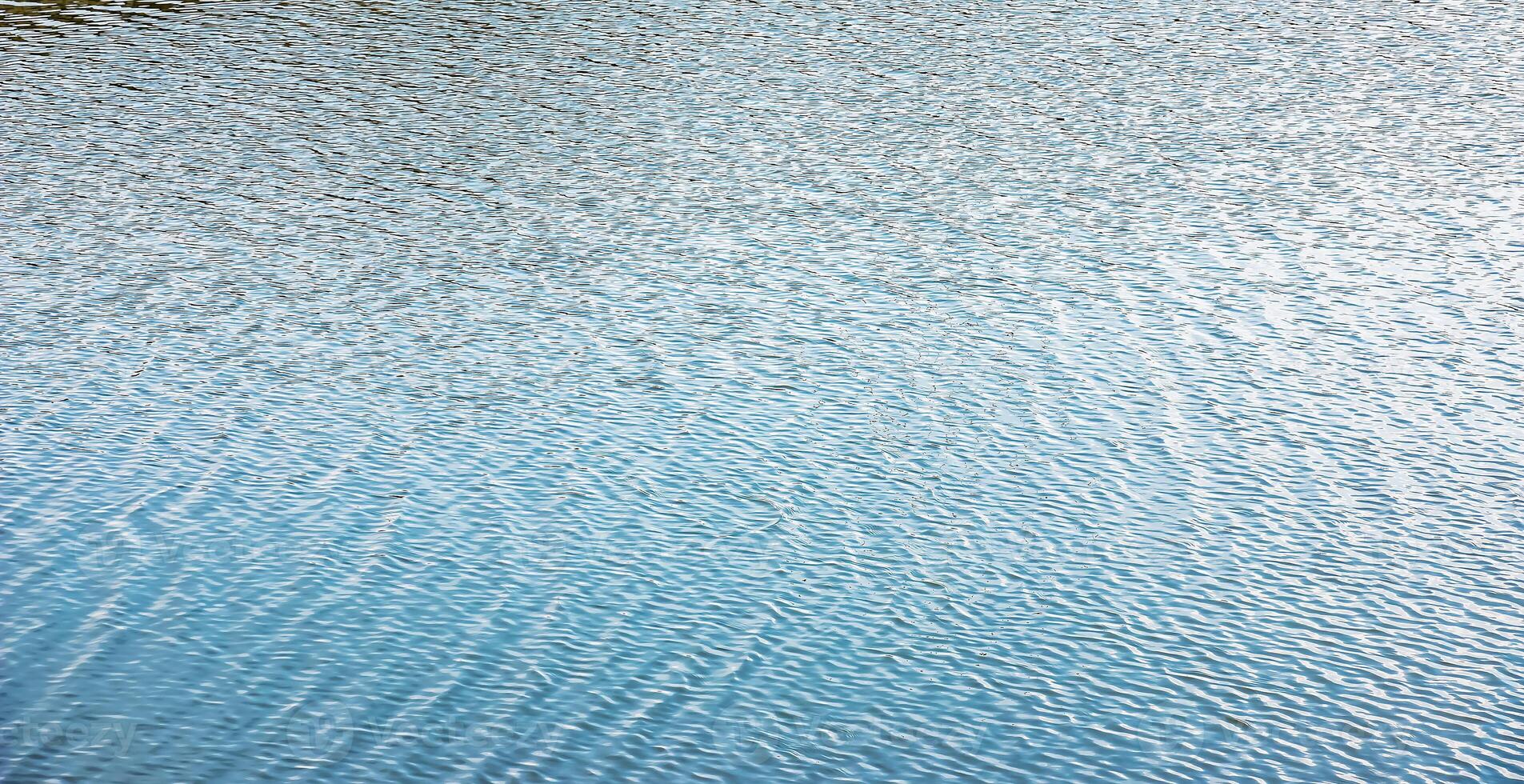 Water surface at sunset, ripples of river with small waves, calm and close-up. Natural background. Abstract background. photo