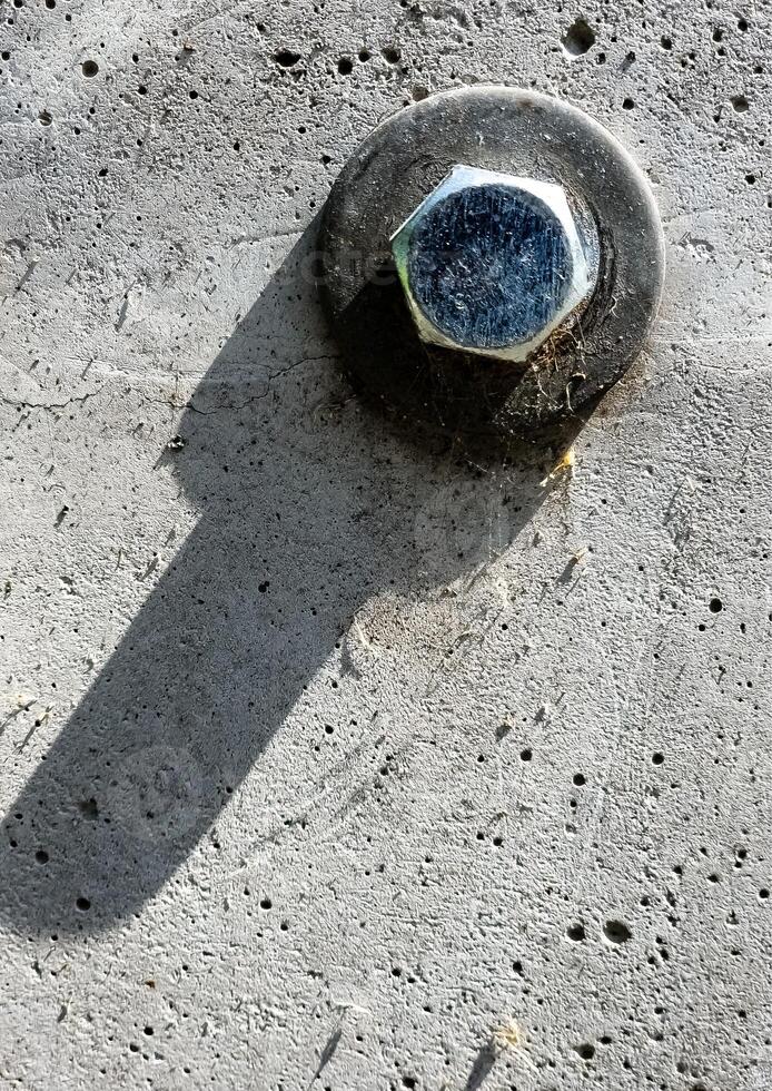 Close up of bolt fastener with washers on concrete surface. photo