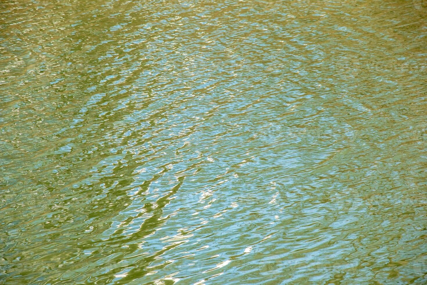 Water surface in sunset rays, river ripples or ocean with small waves, calm and close-up. Natural background. Abstract background. photo