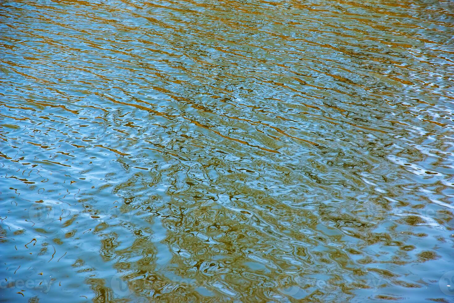 Water surface in sunset rays, river ripples or ocean with small waves, calm and close-up. Natural background. Abstract background, texture. photo
