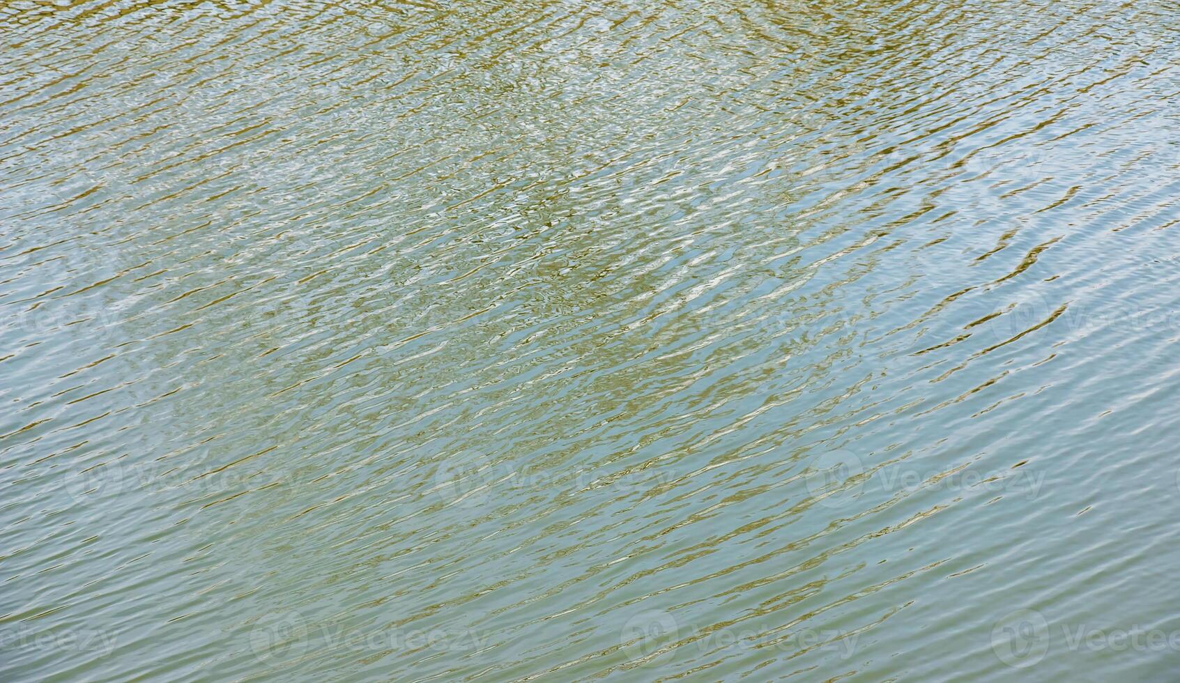 Water surface at sunset, ripples of river or ocean with small waves, calm and close-up. Abstract background, texture. photo