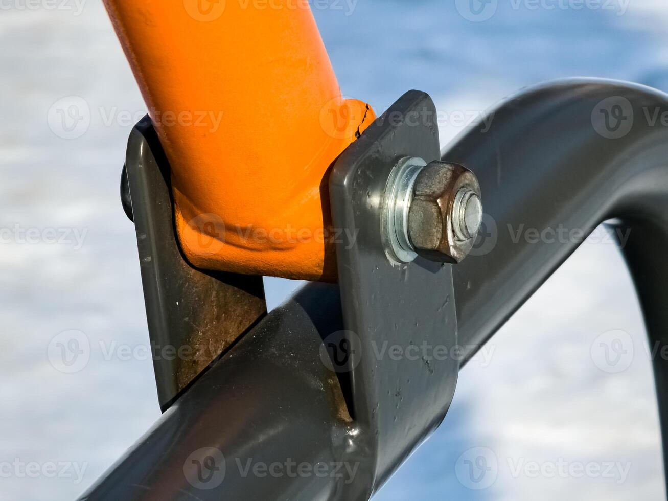 Fastening a bolt with washers and nuts to metal pipe. Close-up. photo