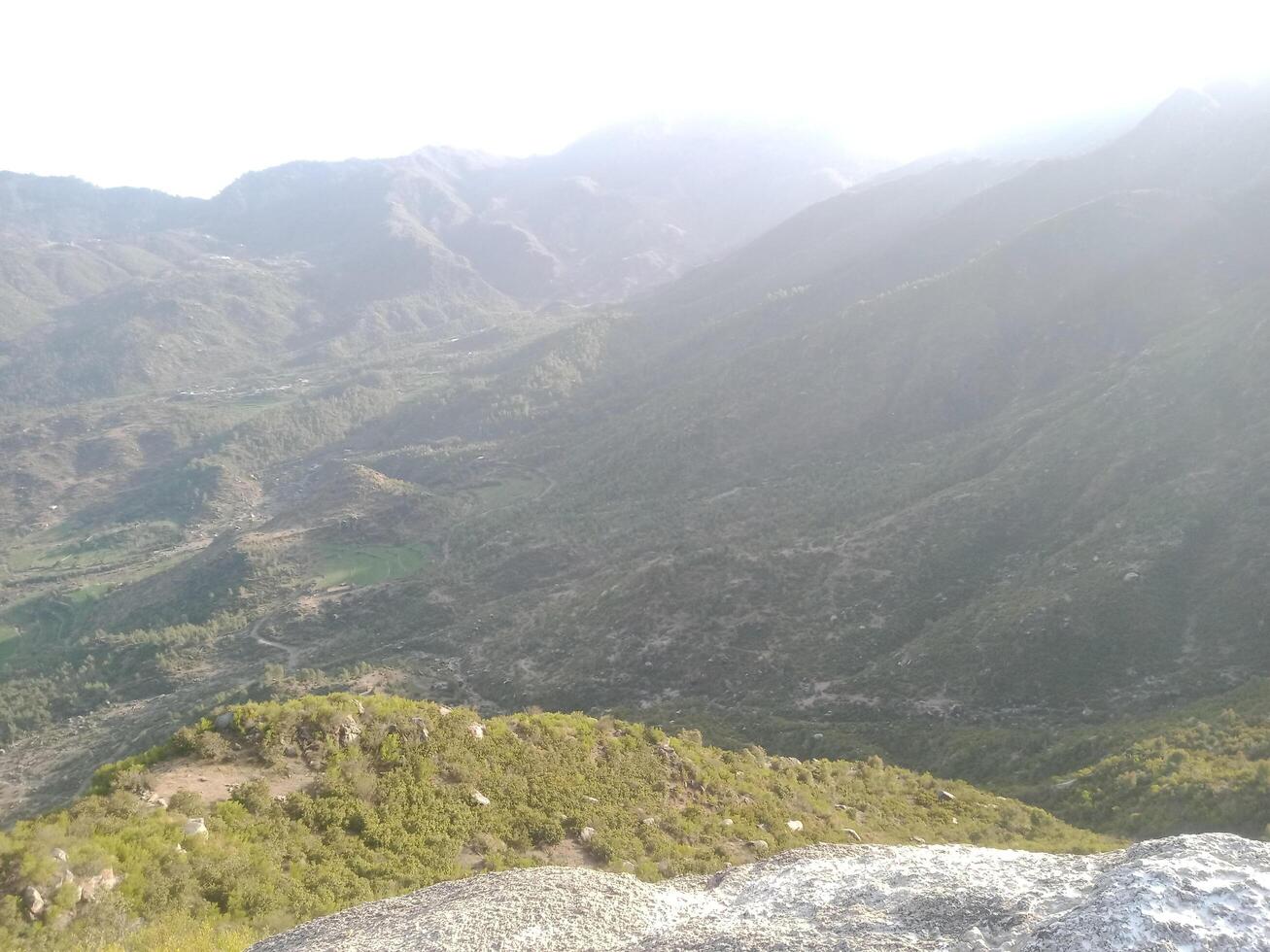Expansive Mountain Valley View with Lush Greenery, Winding Trails, Sunlit Peaks, Rolling Hills, Rocky Terrain, and Scenic Natural Beauty in Daylight photo