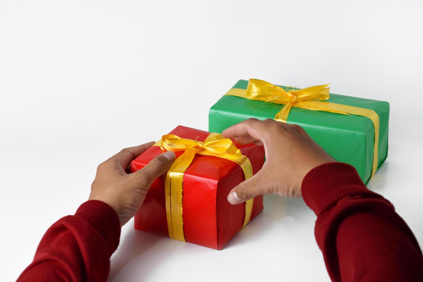 Closeup of Hands Presenting Festive Red and Green Gifts photo
