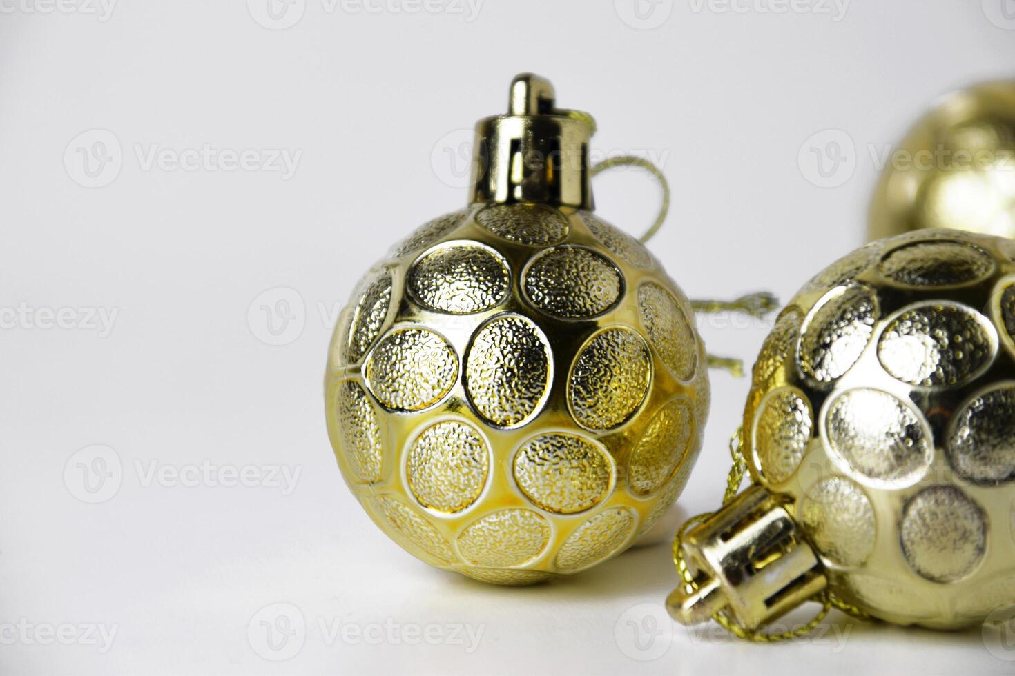 Closeup of three gold Christmas ornaments with textured details photo
