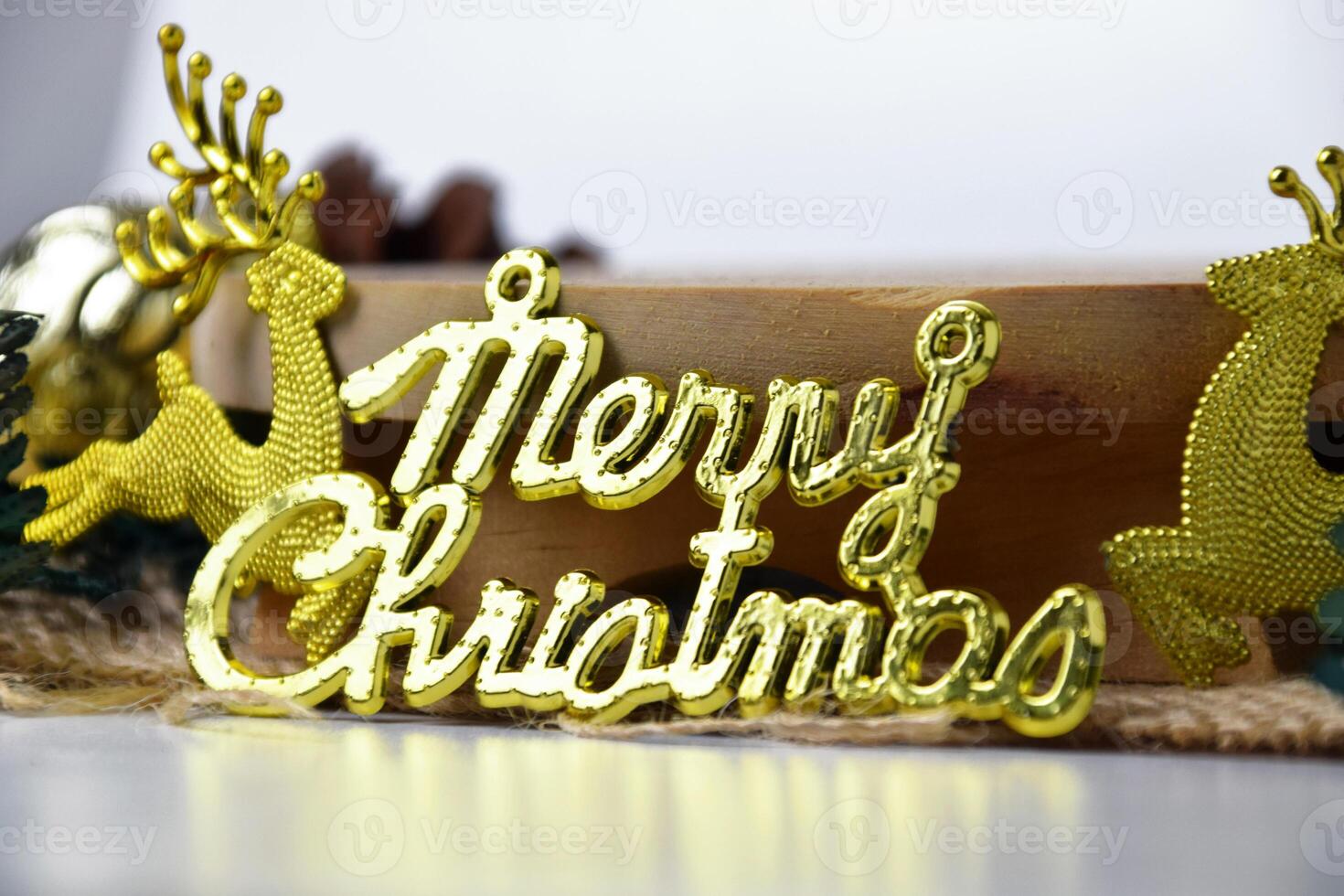 Closeup of gold colored Merry Christmas lettering and decorative ornaments photo