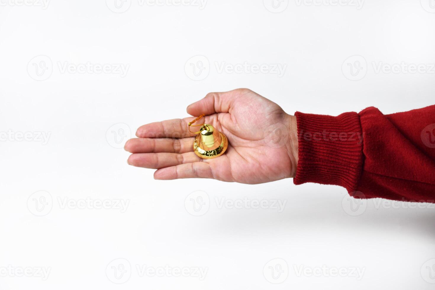 Detailed Close-Up of a Hand Grasping a Golden Bell photo