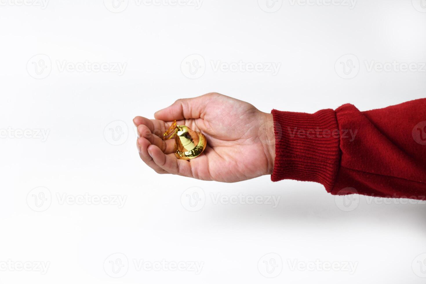 Close-Up of a Hand Holding a Shiny Golden Bell photo