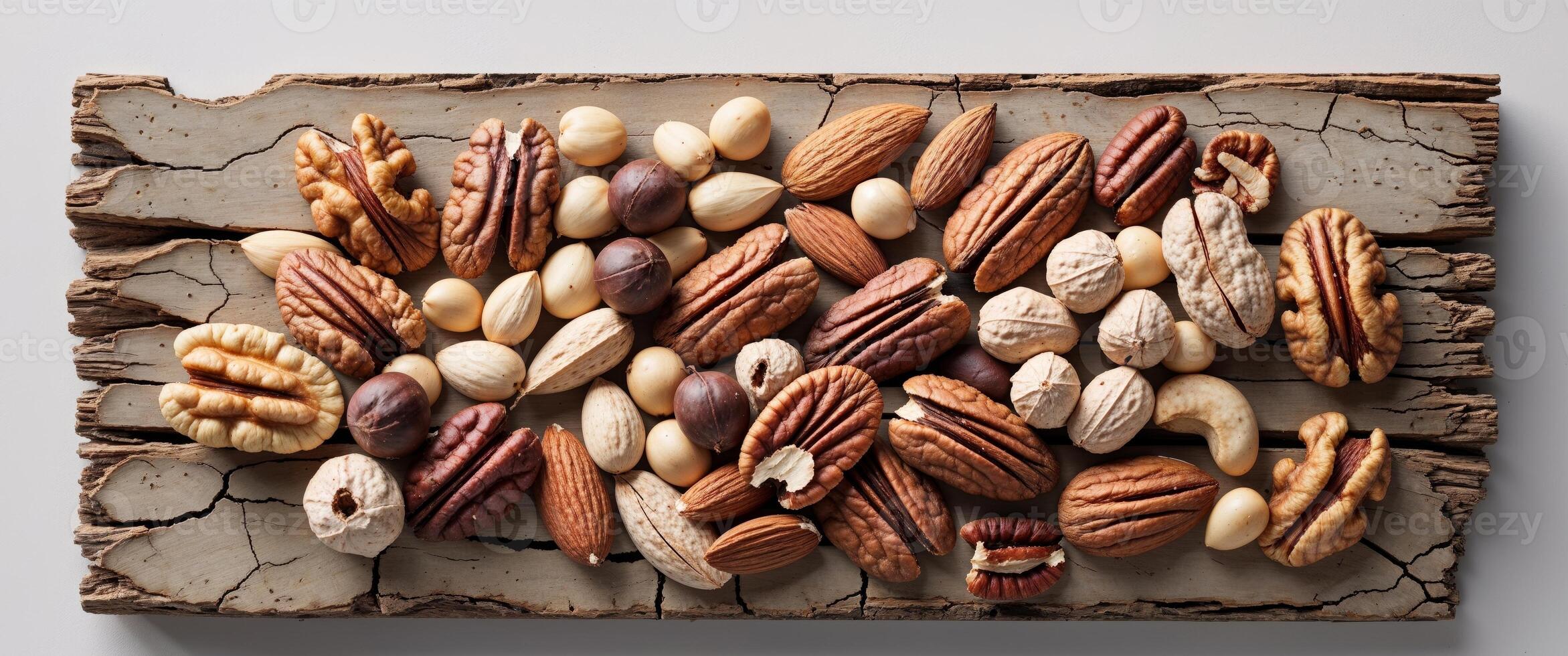 A colorful bunch of various nuts displayed together on a rustic wooden background ready for snacking photo