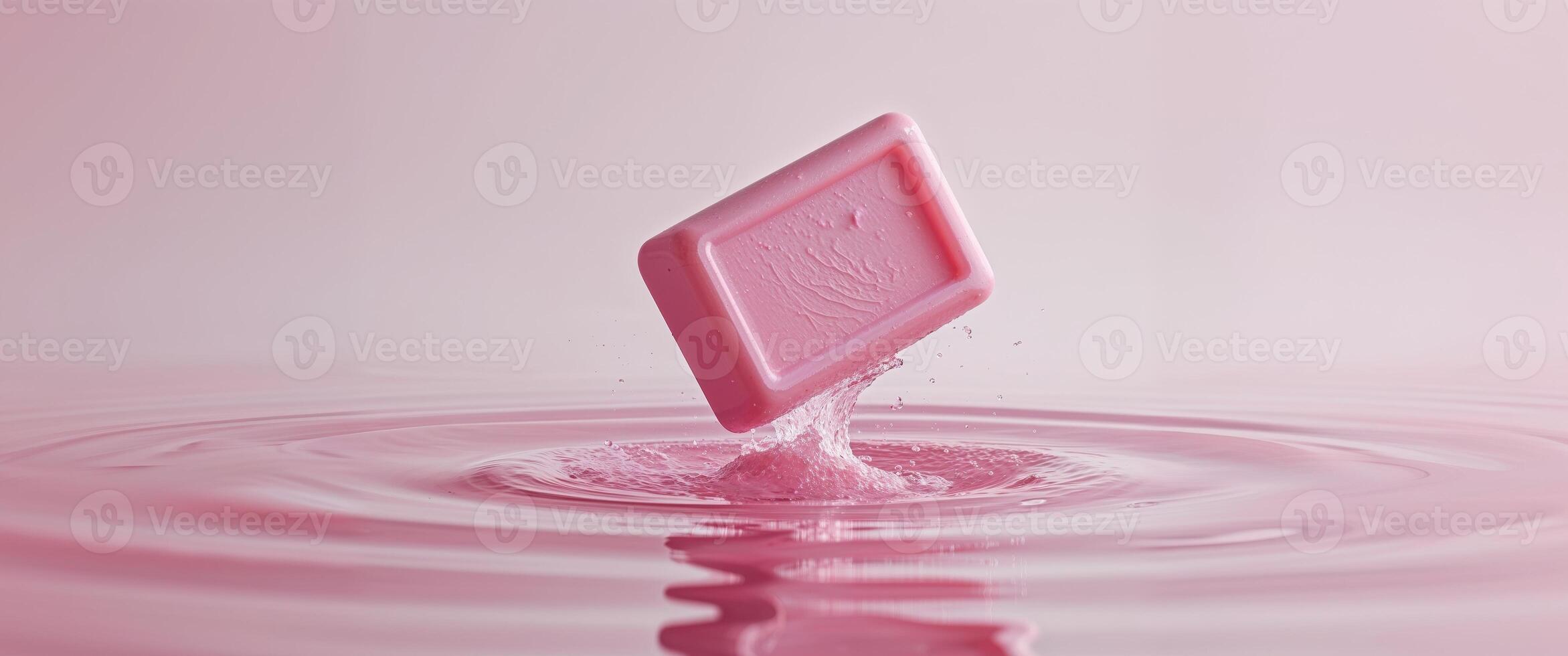 A pink square of soap floating in water photo