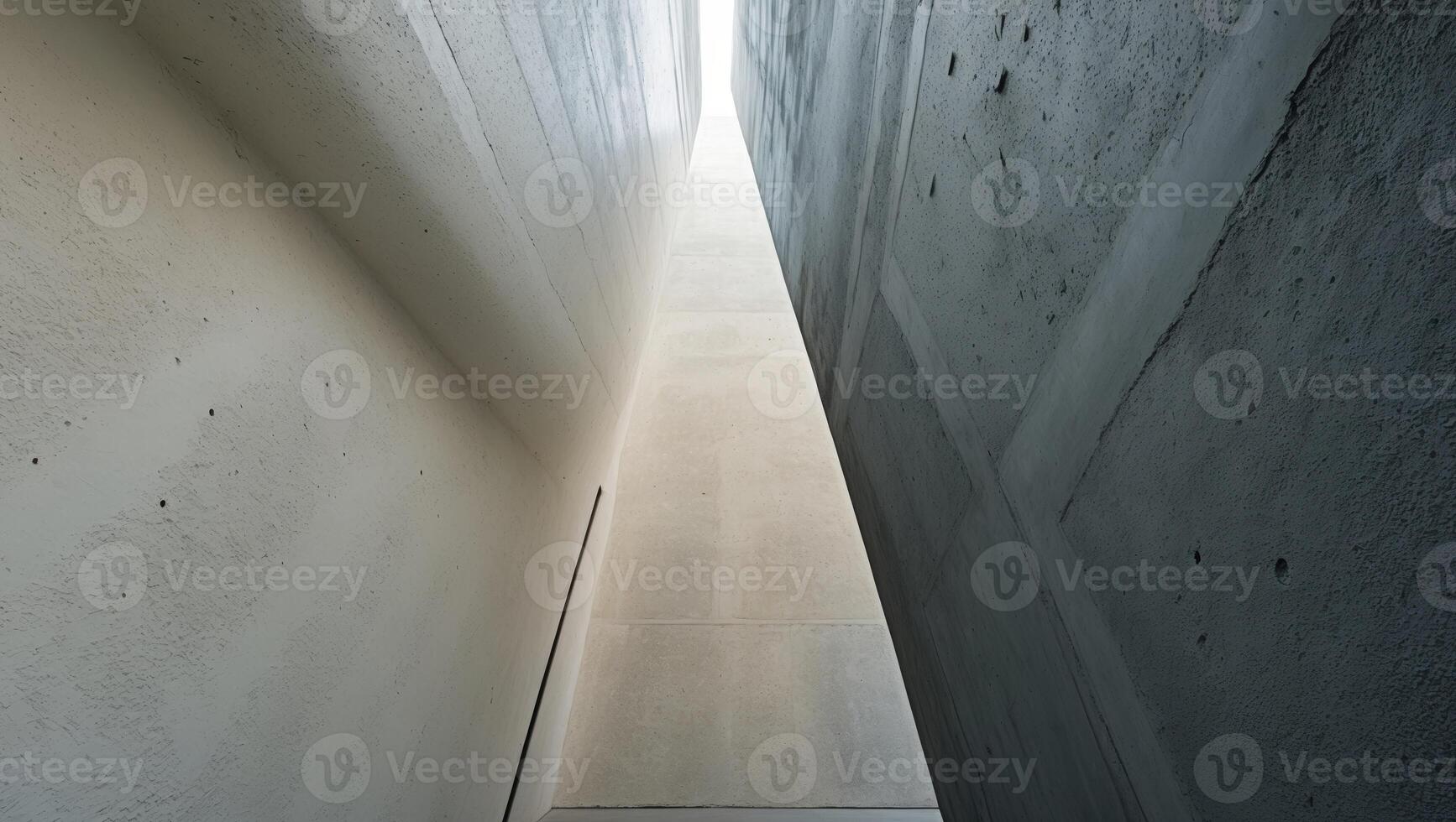 Panoramic view of textured concrete walls with light and dark shades creating contrast and depth in a narrow corridor with high walls photo
