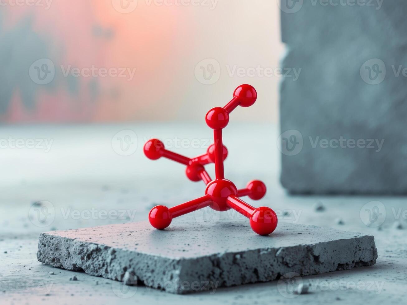 A red model of a molecule on a concrete block photo