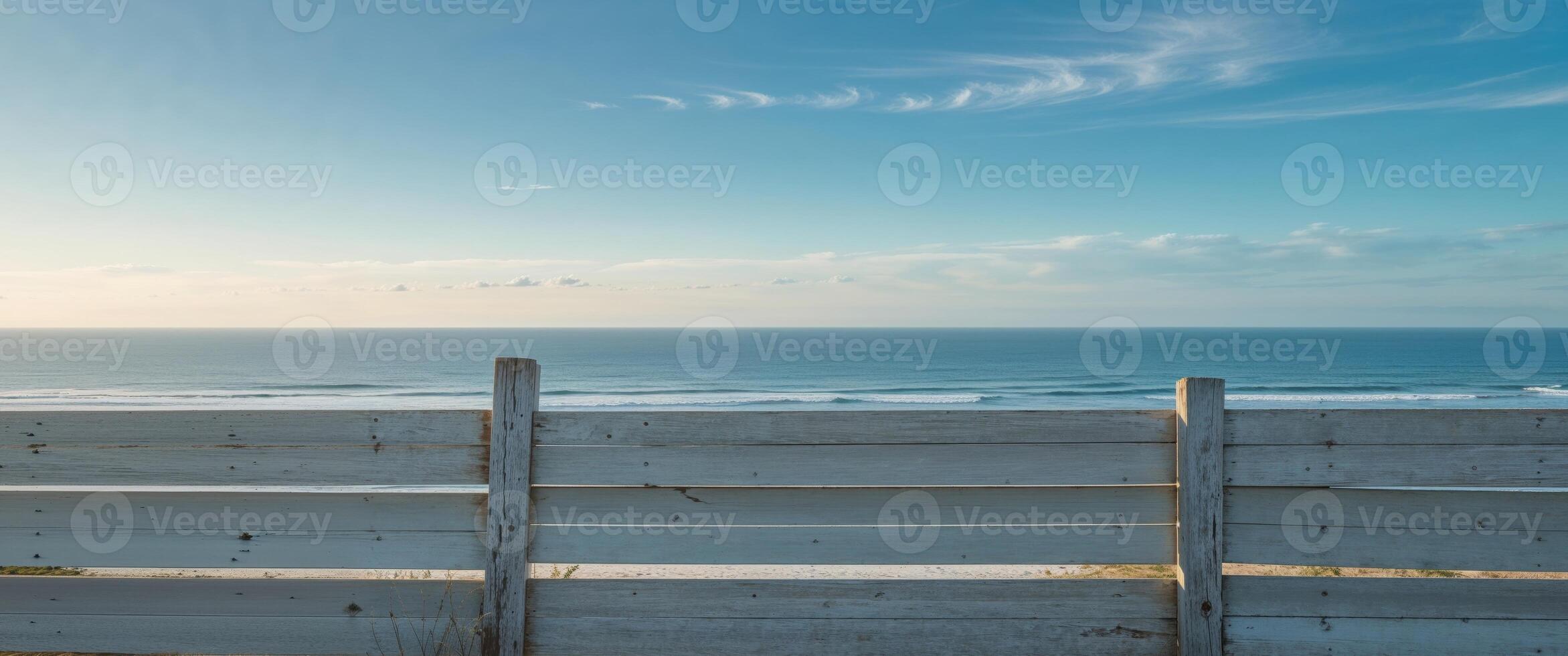 A white fence with a view of the ocean photo