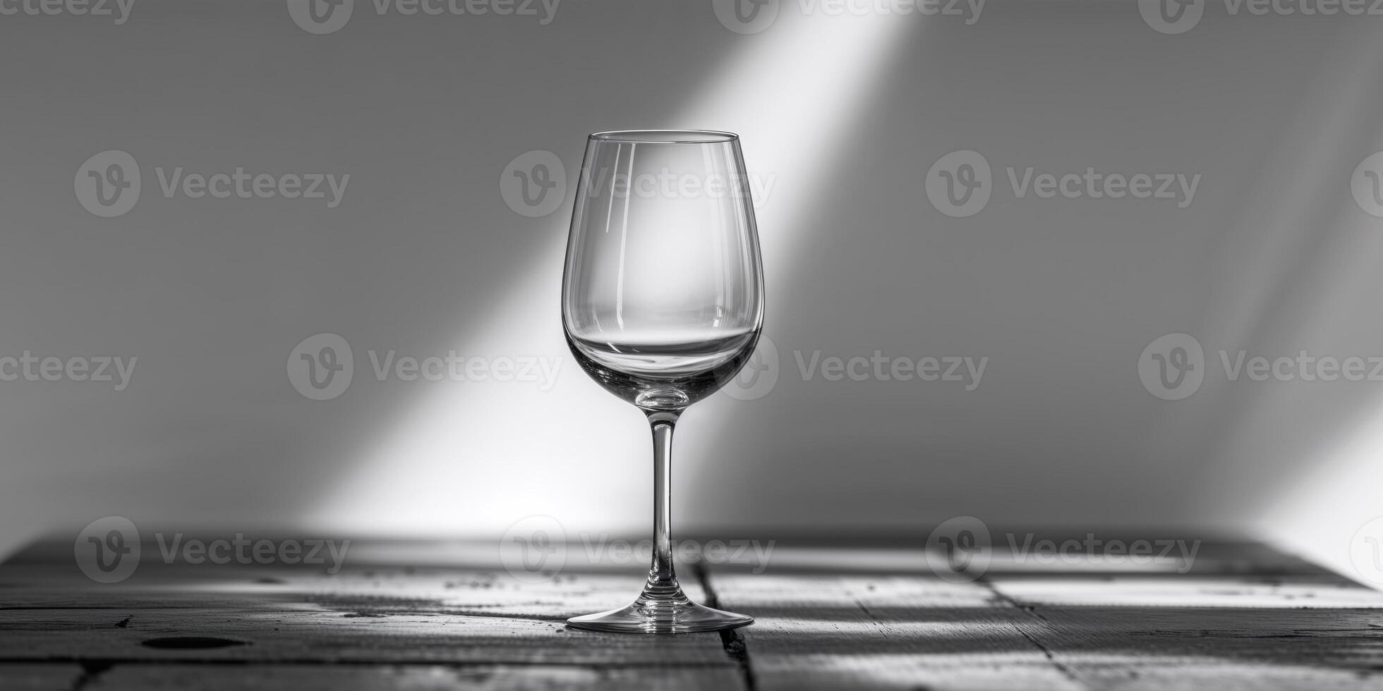 A wine glass is sitting on a table with a shadow of it on the table photo
