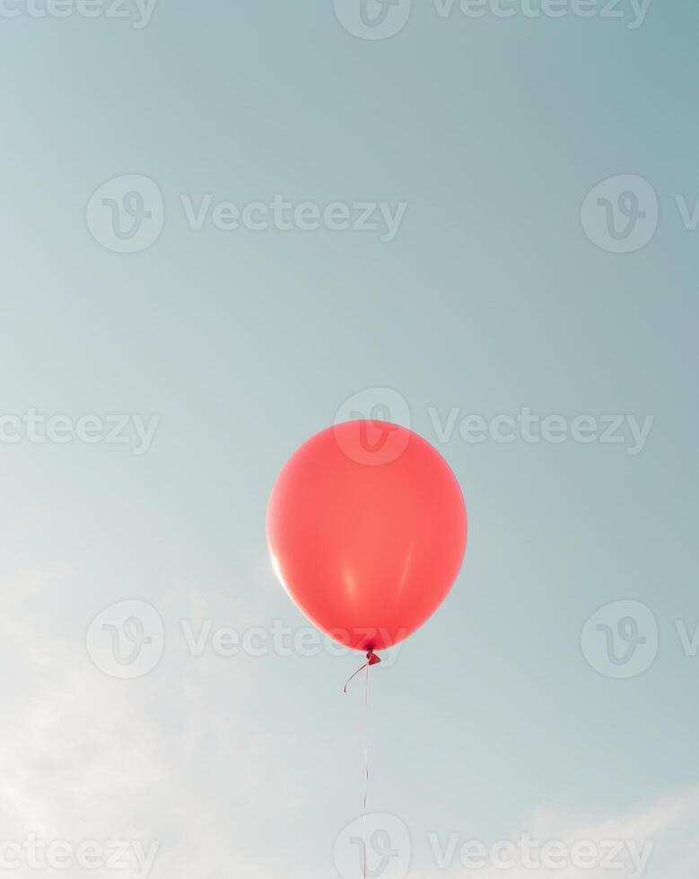A red balloon is floating in the sky photo