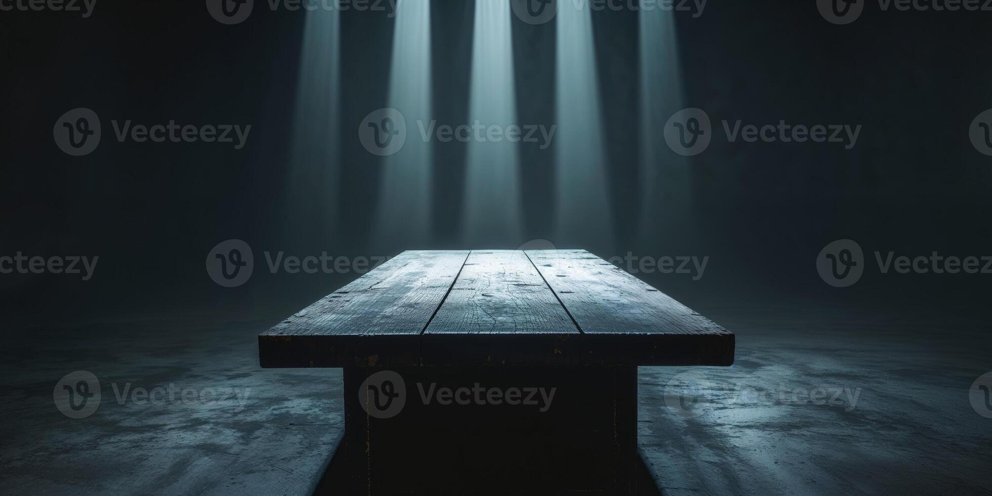 Light beams shine on a wooden tabletop in a dark space. photo