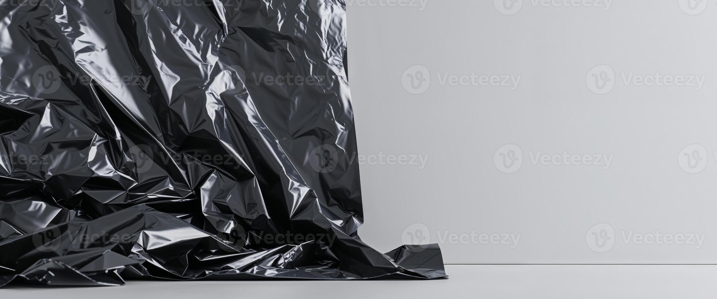 A black plastic bag is sitting on the floor photo