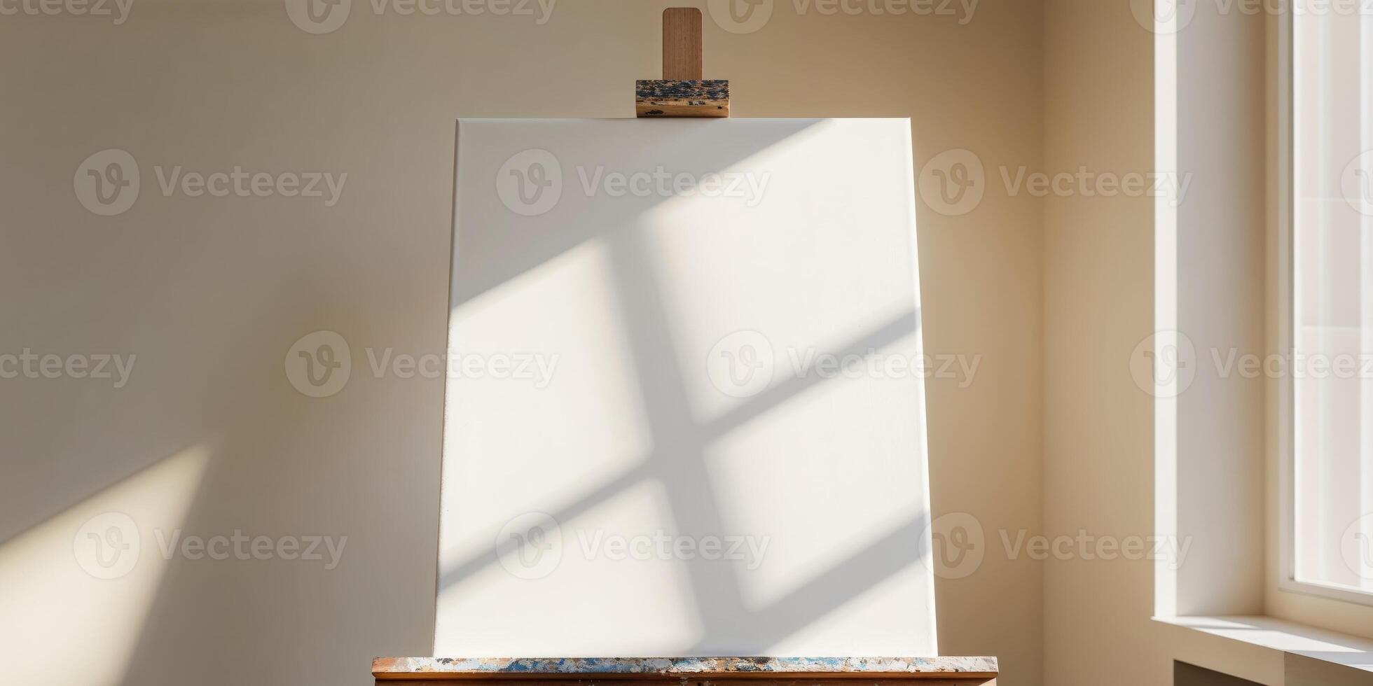 An easel with a white canvas on it in front of a window photo