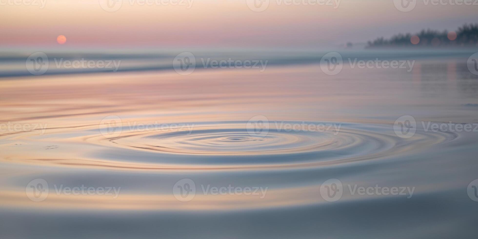 Soft ripples on the surface of calm water reflecting pastel colors at dusk by the sea photo