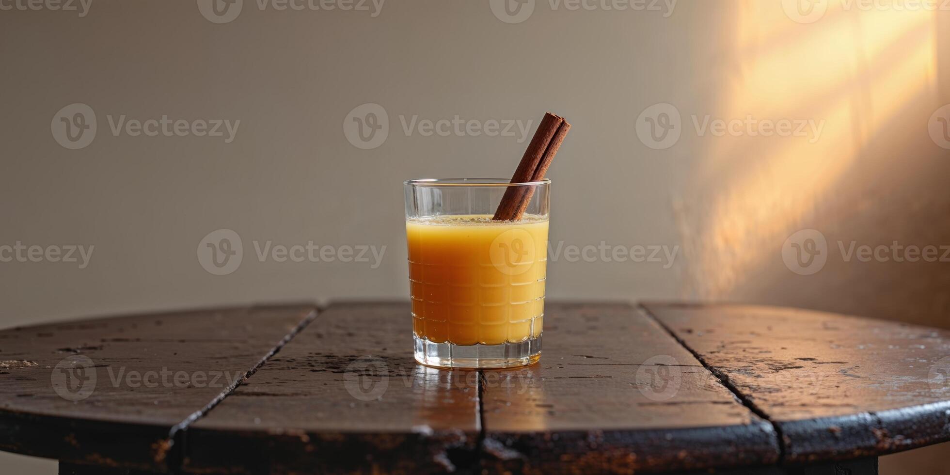 Refreshing Glass of Orange Juice with Cinnamon Stick on Wooden Table photo