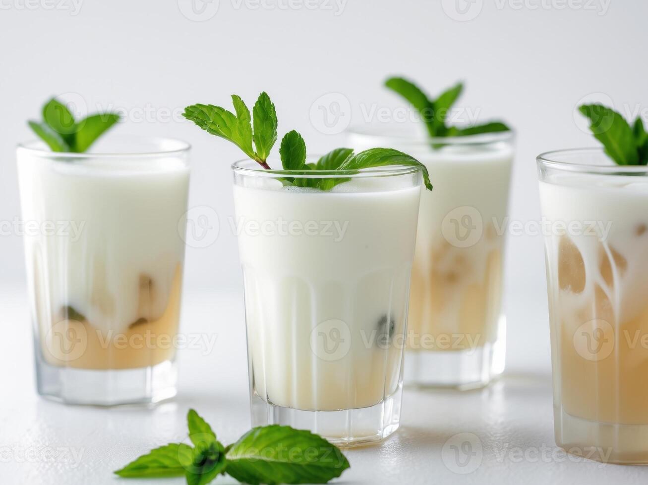Refreshing iced tea drinks layered with milk and garnished with mint. photo