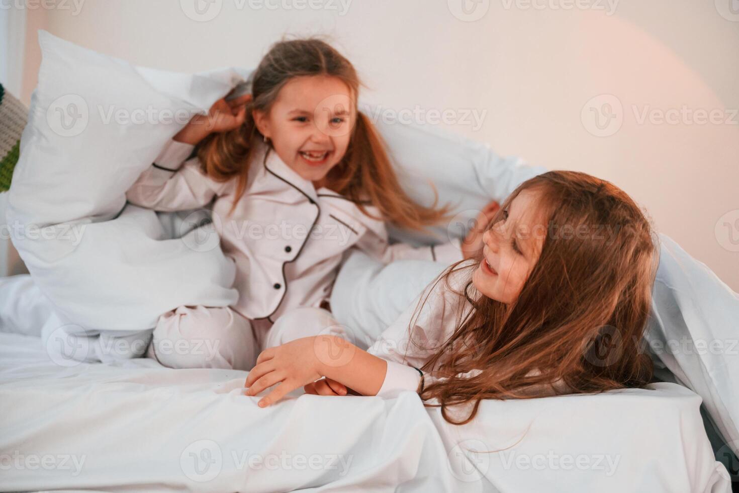 Cheerful, and positive ,two little girls are playing and having fun together in bedroom photo