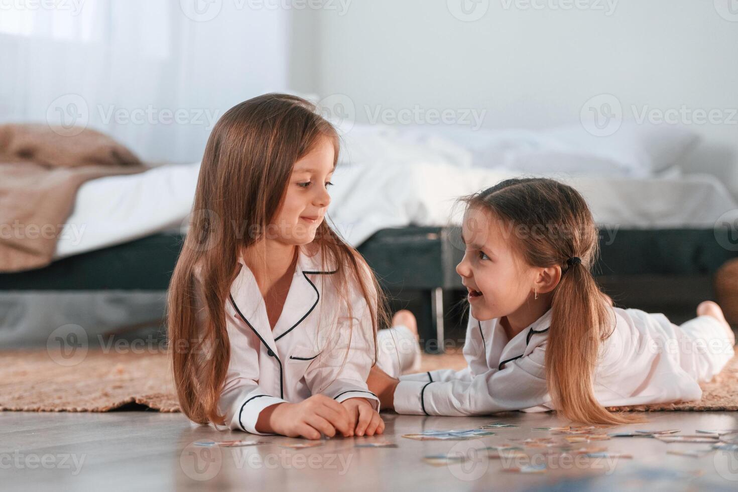 Playing, card game. Two little girls are, together in domestic room photo