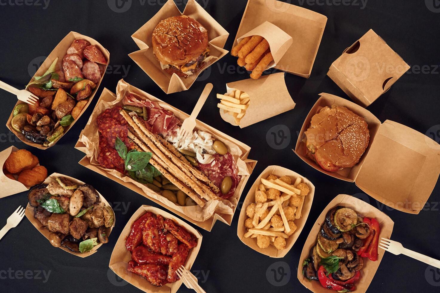 On, the, black colored table. Top view of food on it. Meat, vegetables, French fries, burger, mushrooms photo