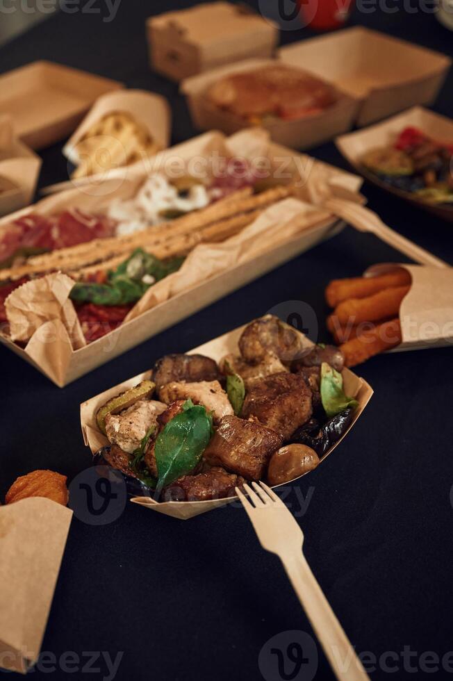 Top view, of table with food on it. Meat, vegetables,, French fries, burger, mushrooms photo