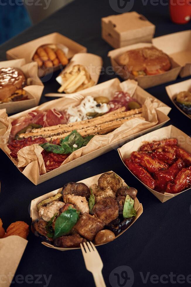 Top view of table with food on it.. Meat, vegetables, French fries, burger, mushrooms photo