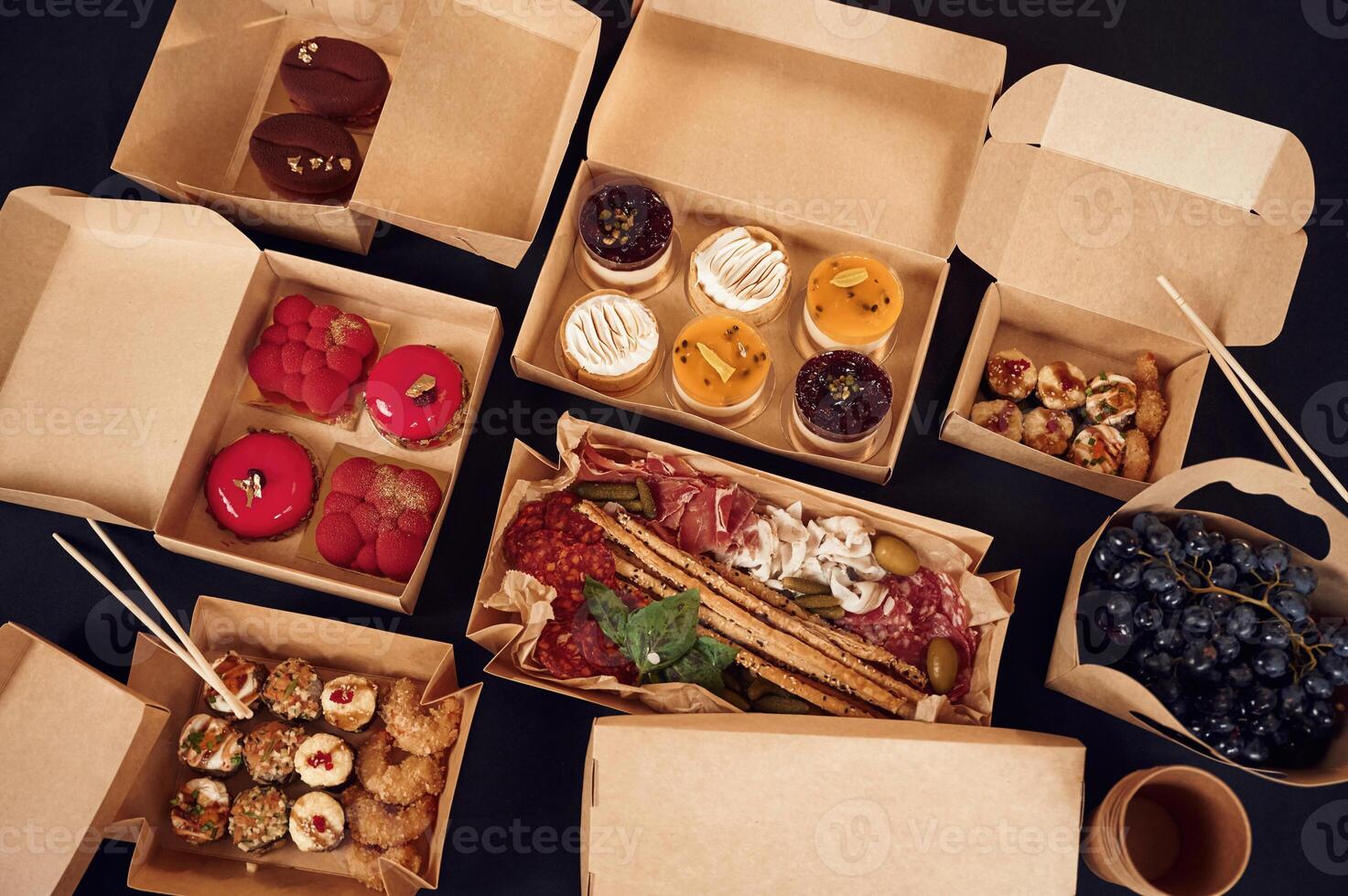 Close up view of table with food on it. Meat, ,vegetables, sushi, French fries, burger, mushrooms photo