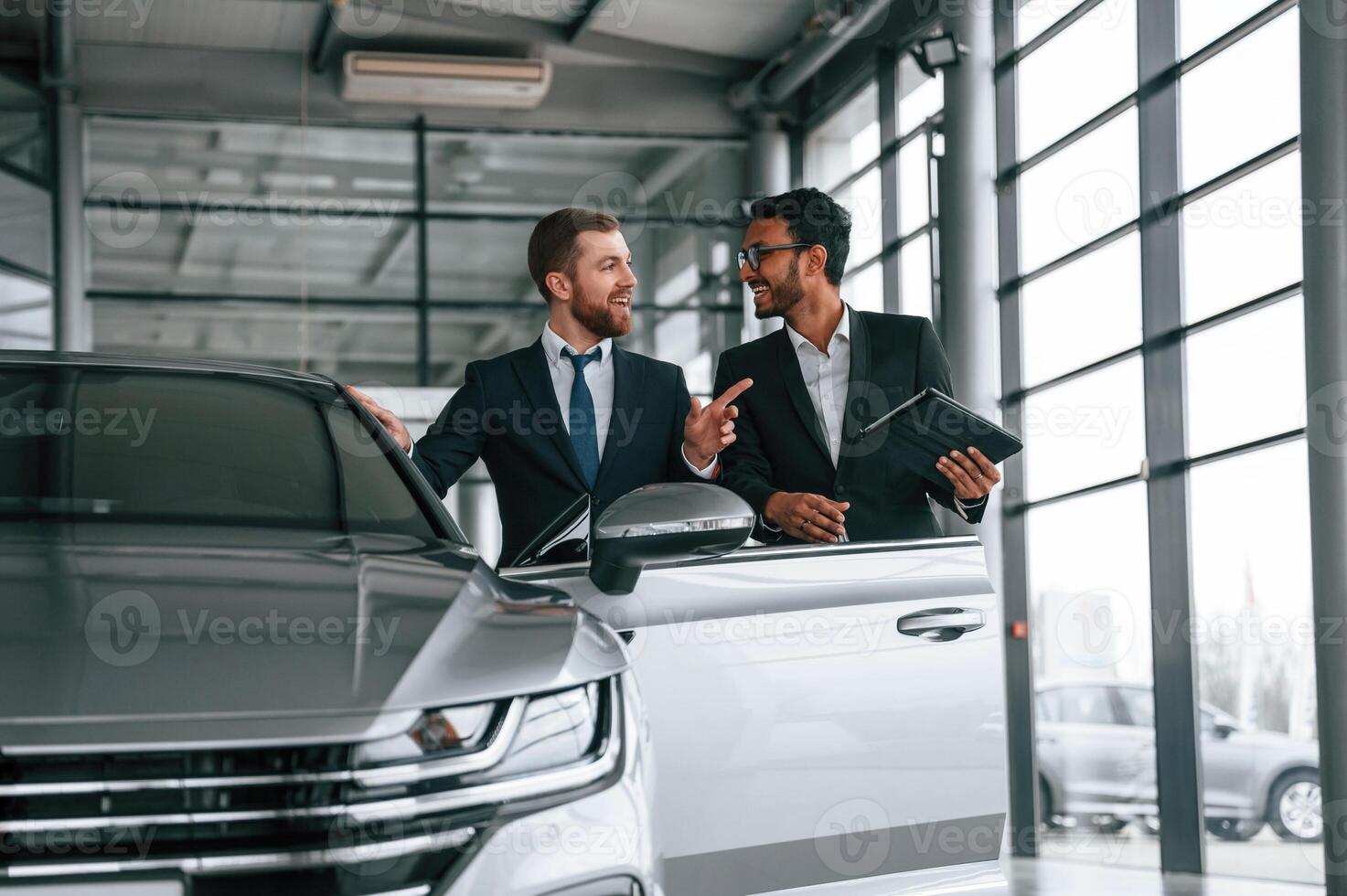 Man is consulting the customer in the car showroom. photo