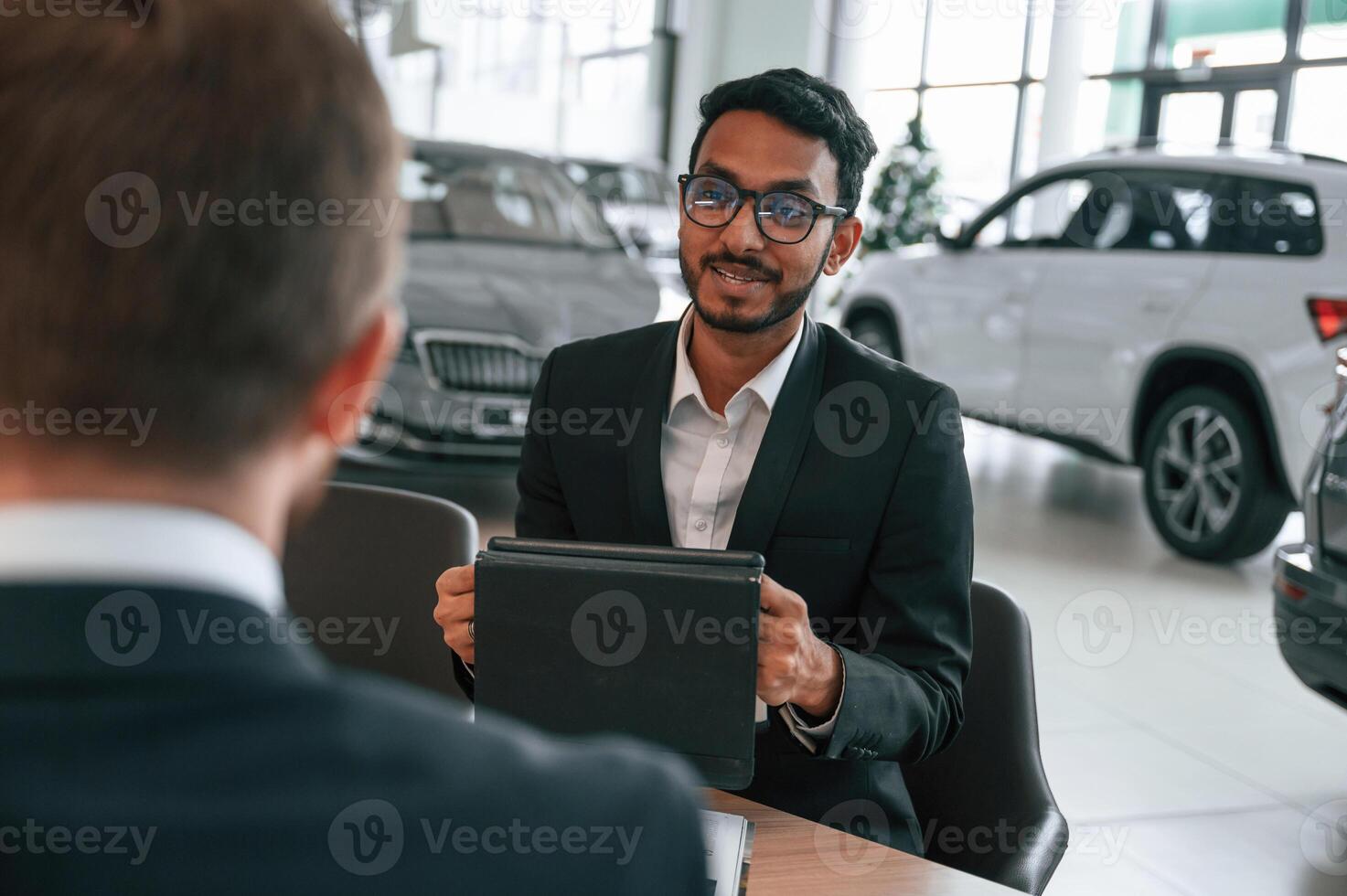 Two businessmen are working together in the, car showroom photo