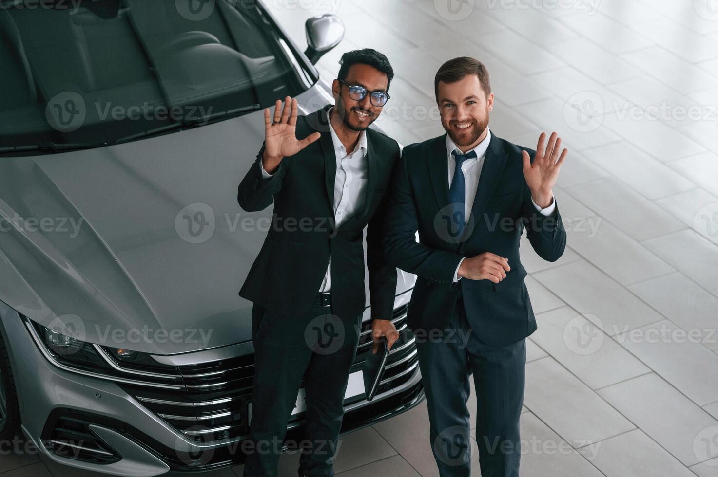 View from the top. Two businessmen are working ,together in the car showroom photo