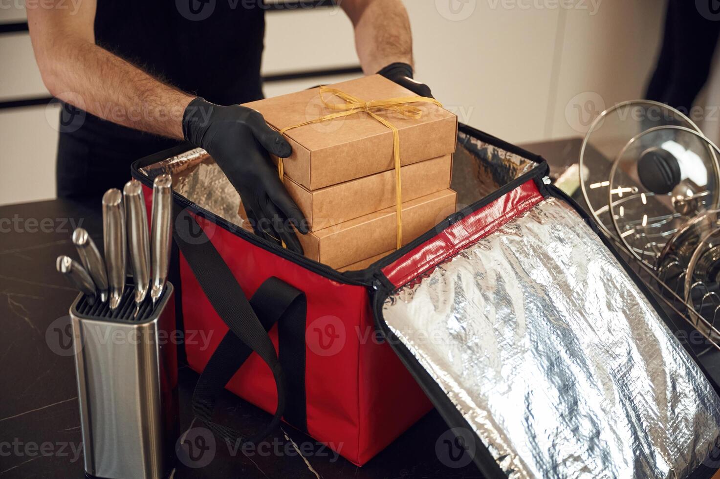 On the table. Man packs paper eco boxes i,nto a bag for food delivery photo