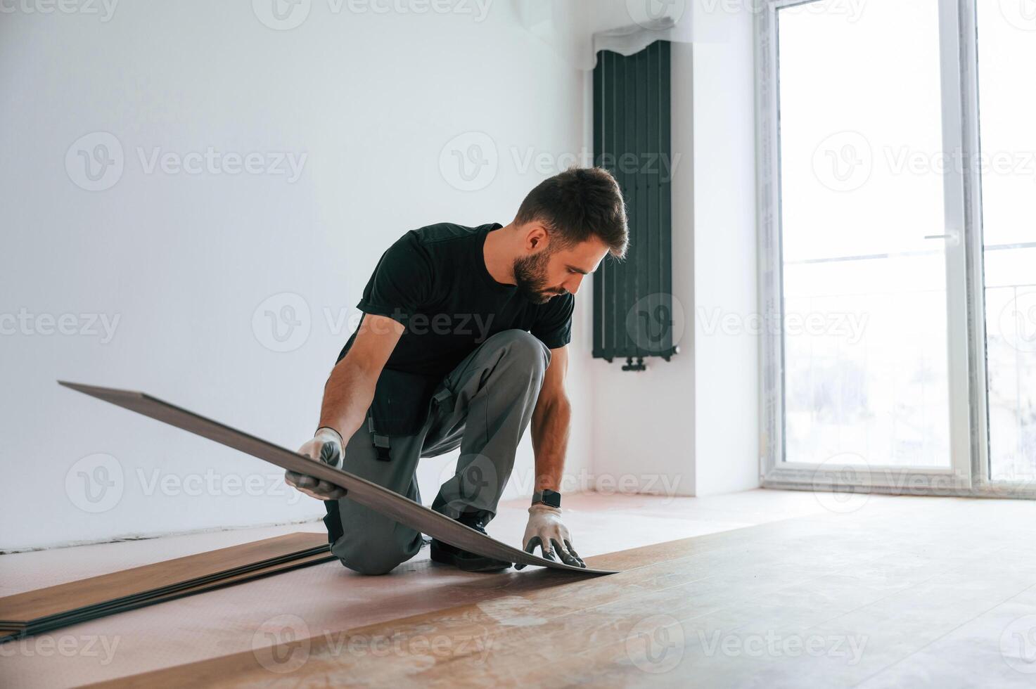 Fitting the planks.. Man is installing new laminated wooden floor photo
