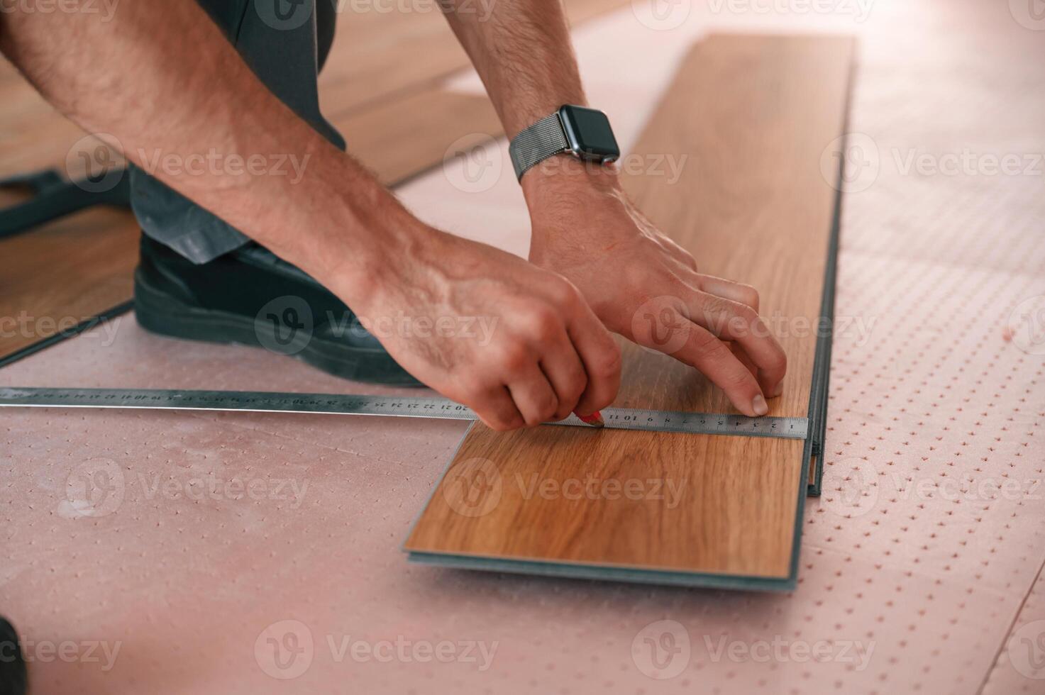 Close ,up view. Man is installing new laminated wooden floor photo