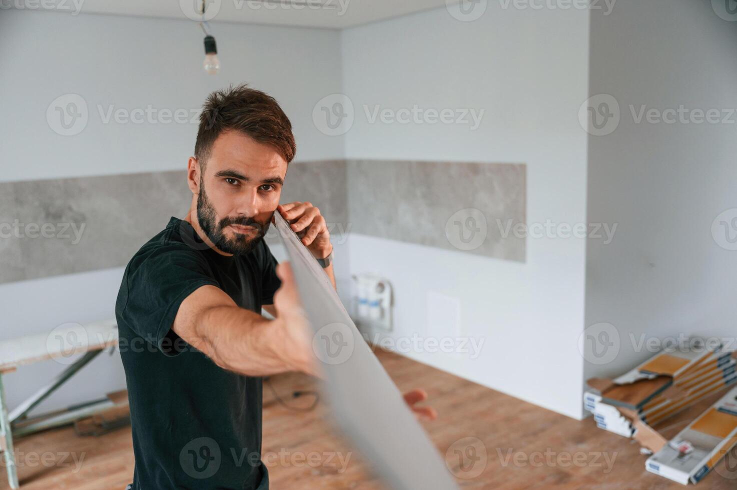 Plank, is in, the hands. Man is installing new laminated wooden floor photo