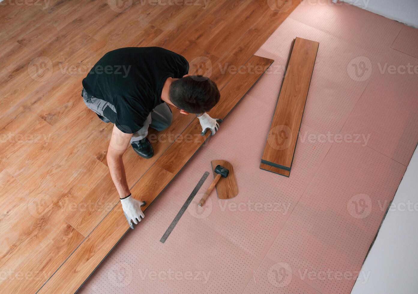 Top view. Man is installing new laminated wooden floor, photo